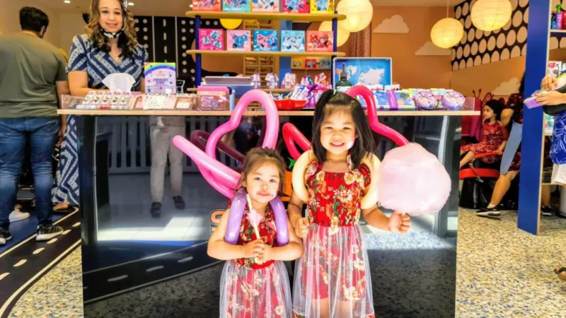Two girls holding balloon animals in the salon