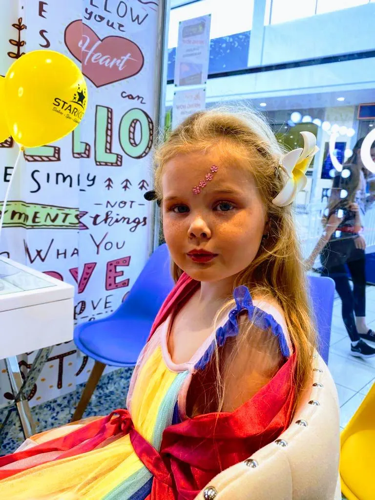 Girl in a rainbow dress at the StarKids salon